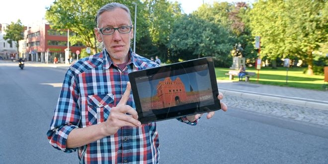 Wolfgang Graemer steht an der Roten Straße. Auf seinem Laptop zeigt er eine Ansicht des Roten Tores, das dort einst stand. Der Lüneburger rekonstruiert mit einer Software alte Ansichten der Stadt. Foto: be